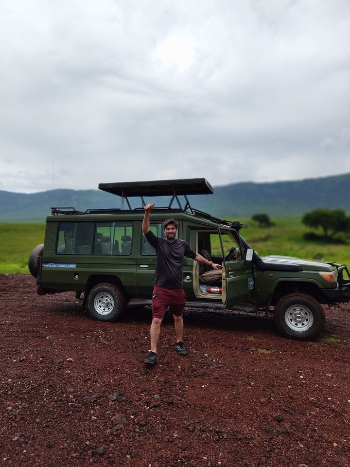 Une personne qui pose devant un véhicule de safari.