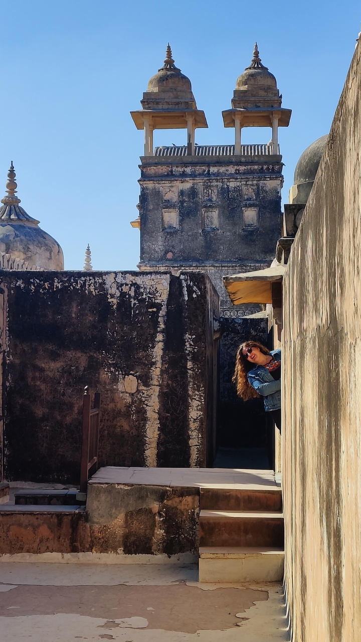 Femme qui jette un coup d'œil depuis derrière une structure ancienne.
