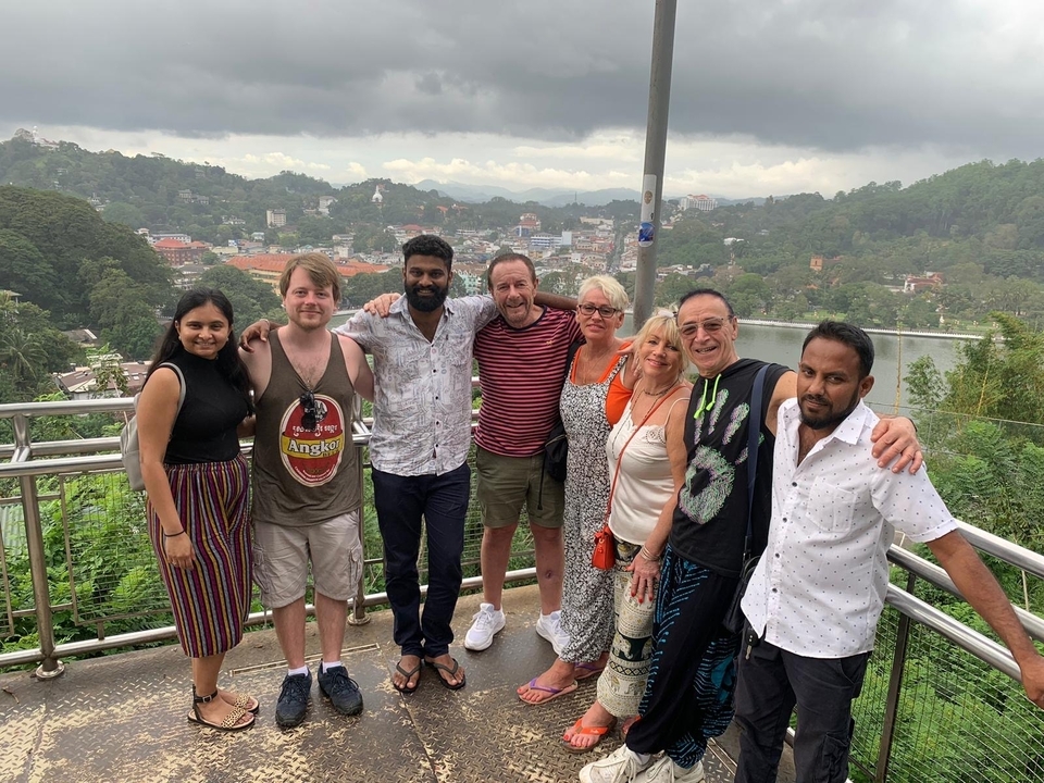 Groupe de personnes posant pour une photo avec une vue panoramique de la ville en arrière-plan.