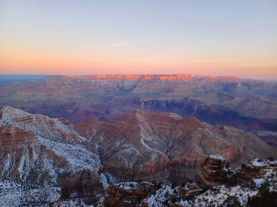 Le Grand Canyon au coucher du soleil avec des couches de couleurs sur le paysage rocheux.