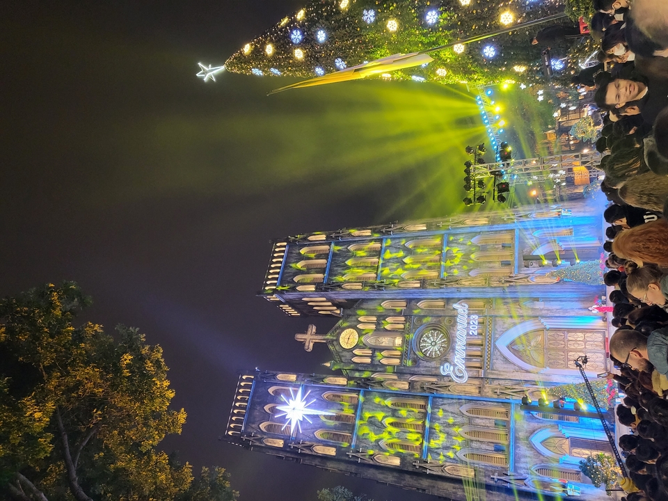 Bâtiment illuminé avec une foule la nuit.