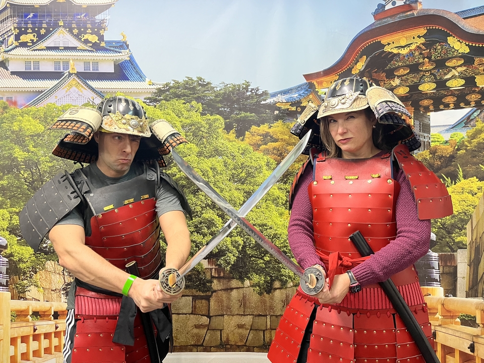 Deux personnes portant une armure de samouraï posent avec des épées.