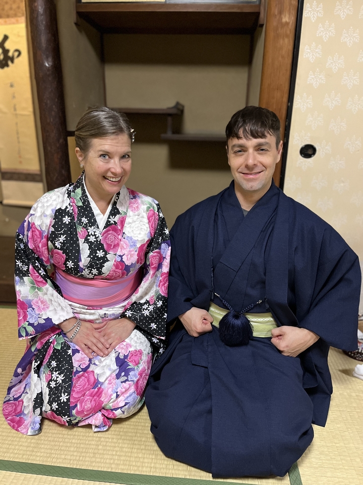 Deux personnes en tenue traditionnelle japonaise assises à l'intérieur.