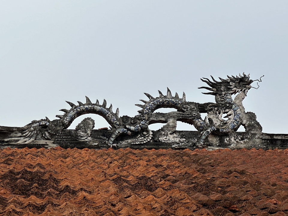 Toit décoratif avec une sculpture de dragon.
