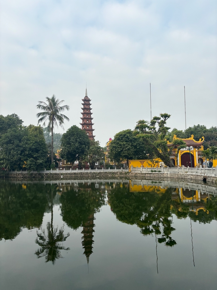 Pagode Tran Quoc au bord d'un lac serein avec des reflets d'arbres.