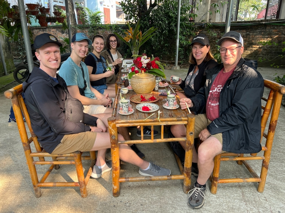Un groupe de personnes assises à une table de restaurant en plein air.