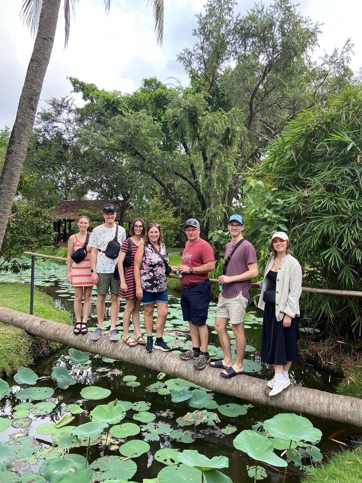 Un groupe de personnes posant dans un jardin luxuriant avec des nénuphars.