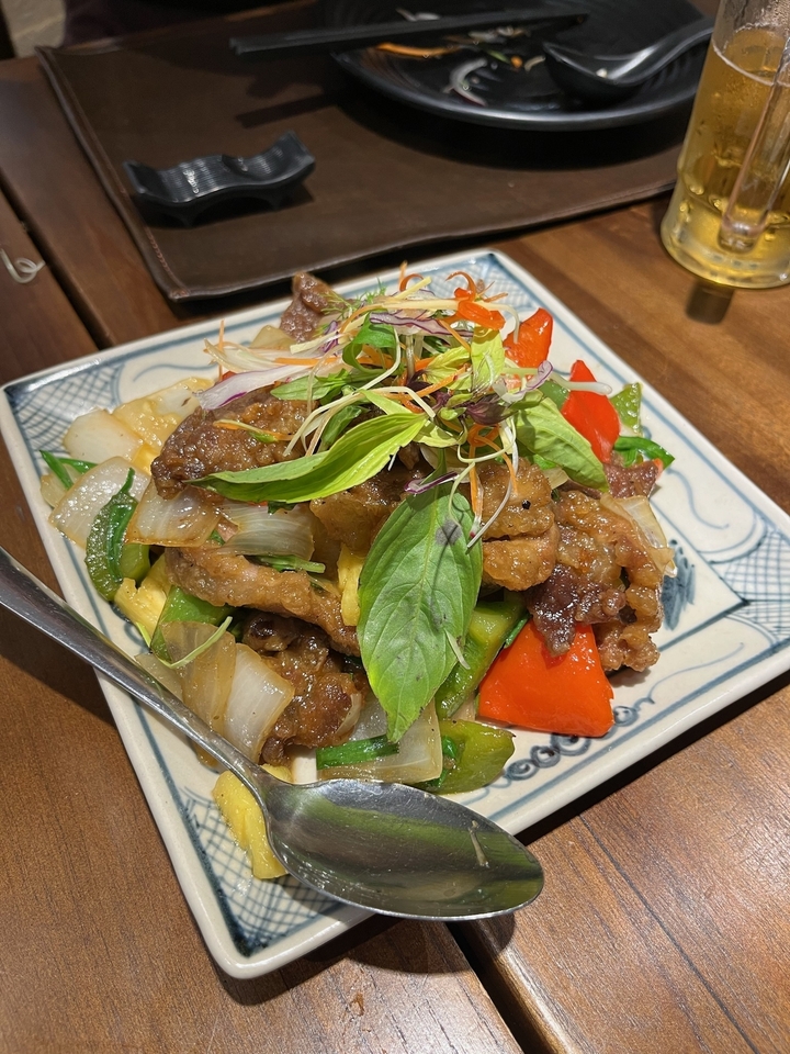 Un plat avec des légumes et de la viande, garni d'herbes fraîches.