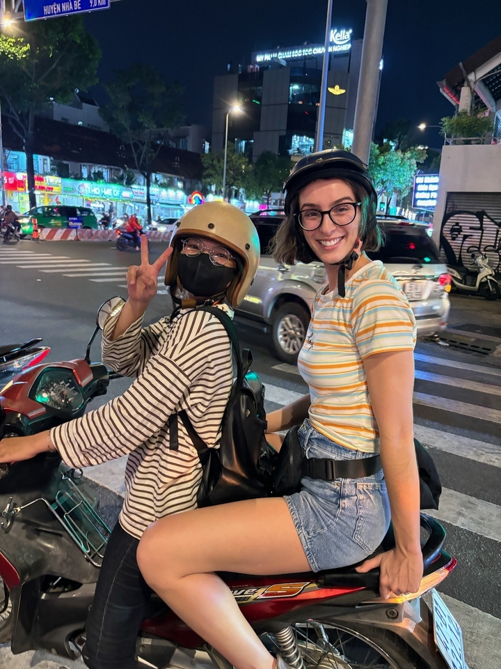 Deux personnes sur une moto la nuit.
