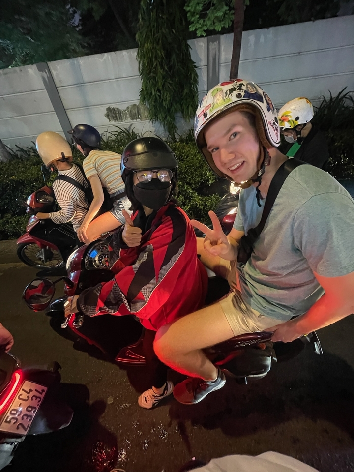 Des gens sur des motos dans une rue animée la nuit.