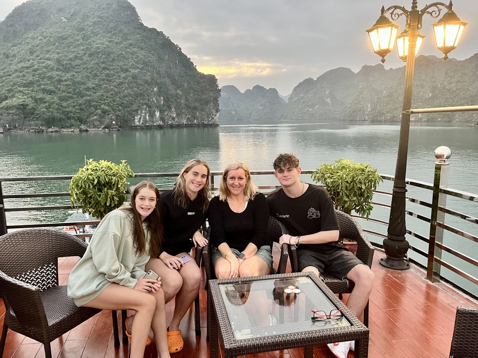 Groupe de personnes assises sur un bateau avec une vue panoramique sur l'eau et les montagnes.
