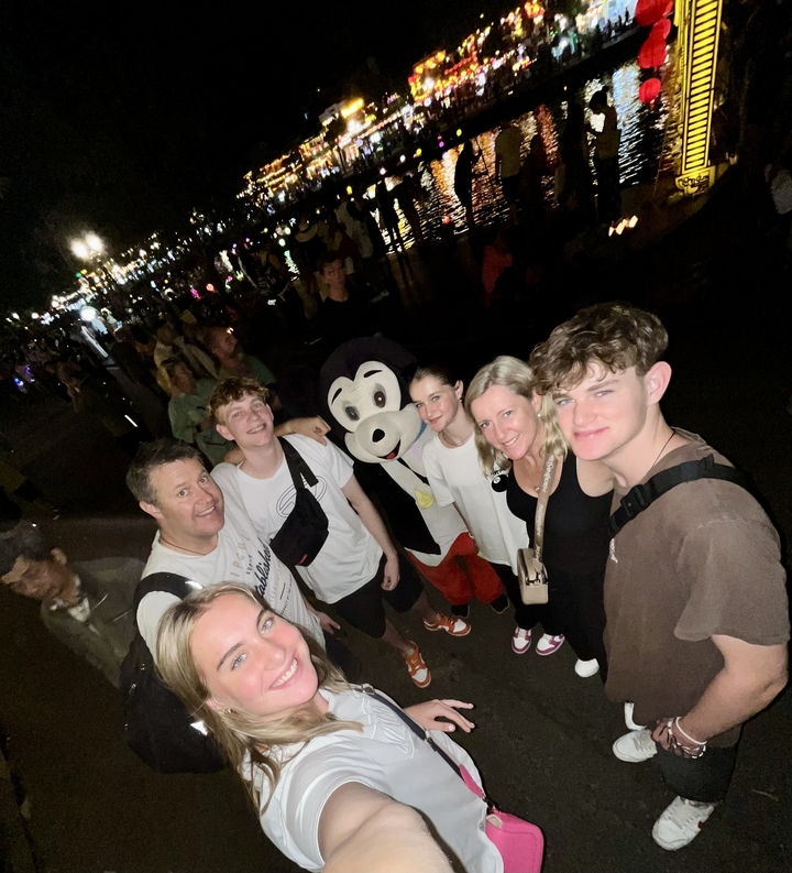 Famille posant la nuit avec une personne déguisée.