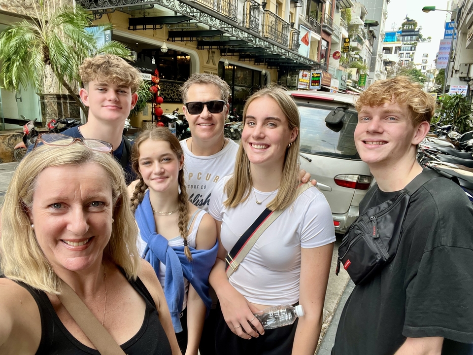 Famille posant dans une rue avec des magasins en arrière-plan.