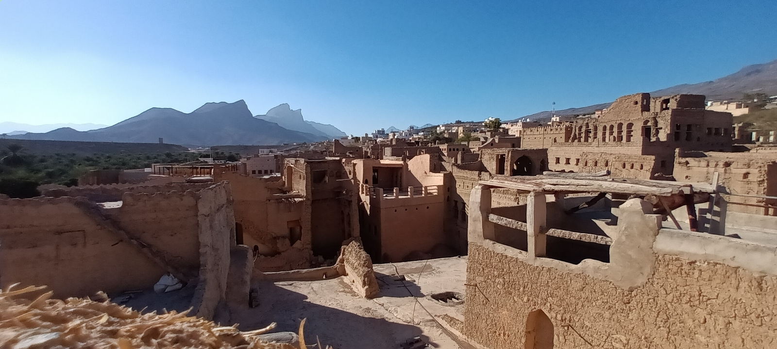 Vue panoramique d'un village ancien avec des montagnes en arrière-plan.