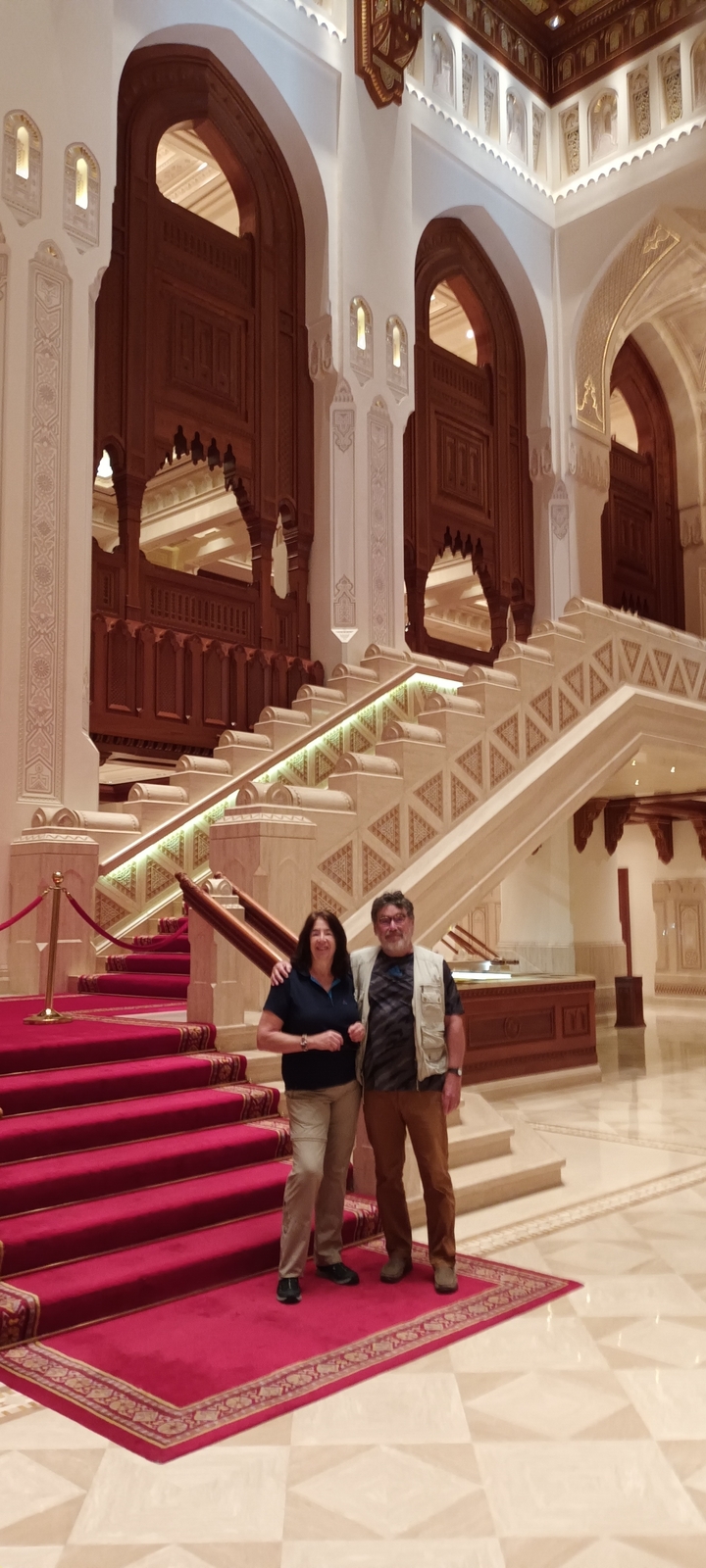 Couple posant sur un escalier luxueux à l'intérieur.