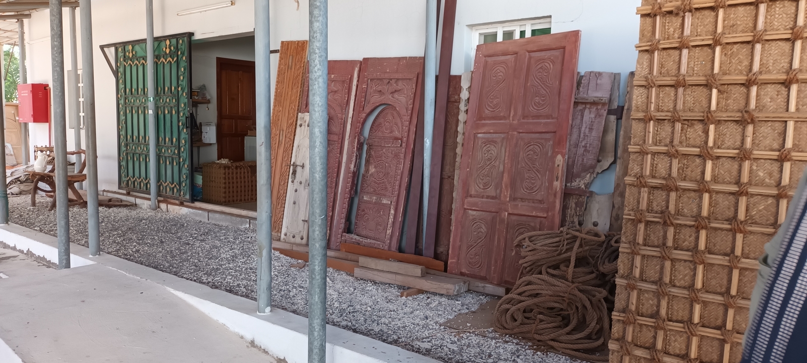 Atelier extérieur avec panneaux de bois et cordes traditionnelles.
