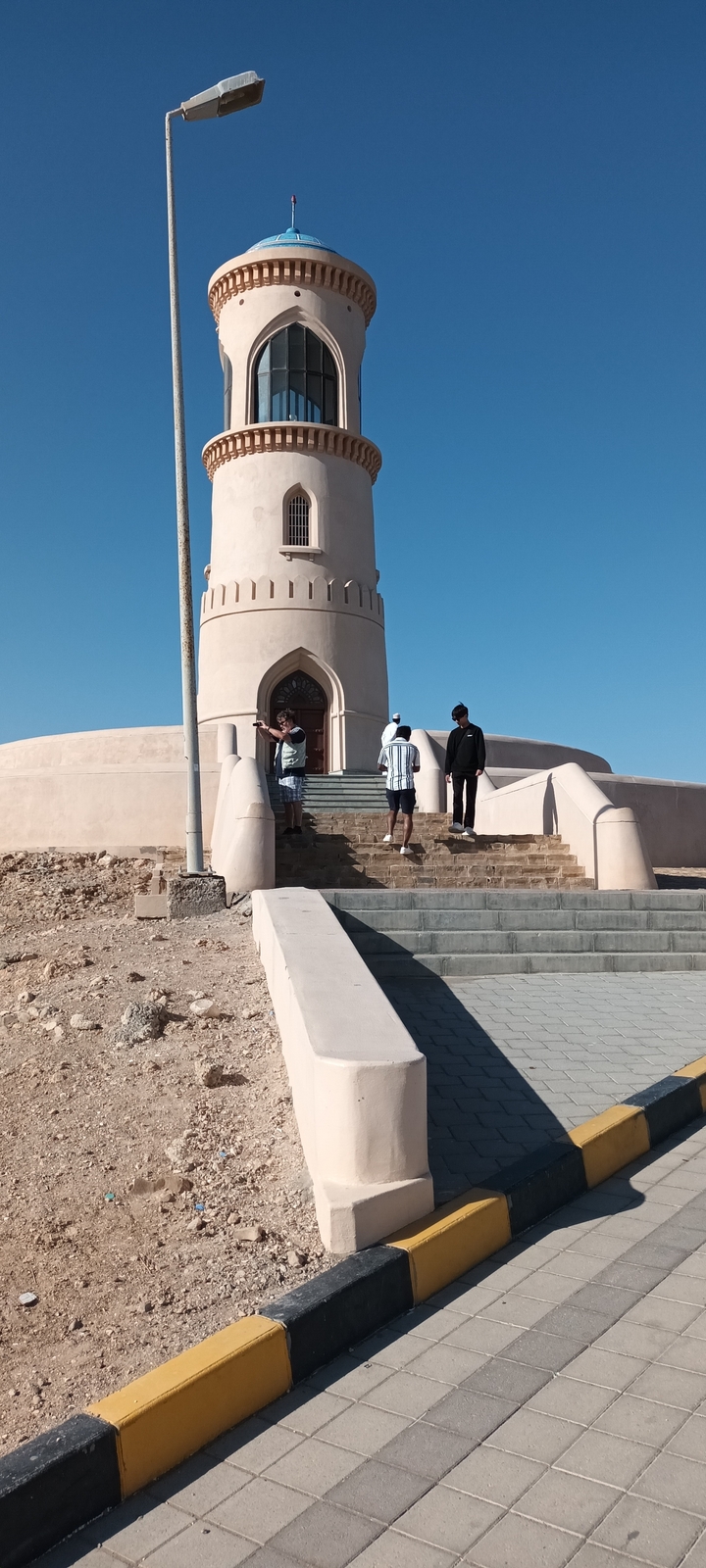 Des gens qui montent les marches d'un bâtiment en forme de dôme.