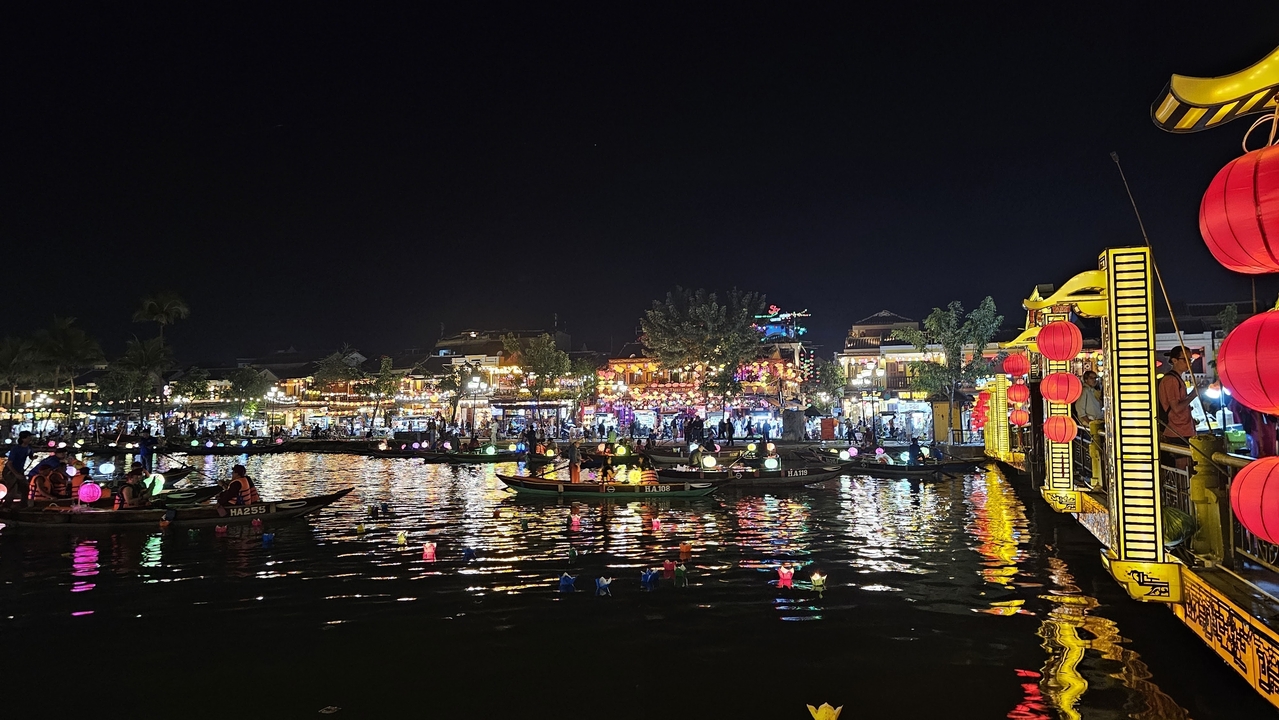 Scène colorée illuminée de lanternes au bord de la rivière à Hoi An la nuit.