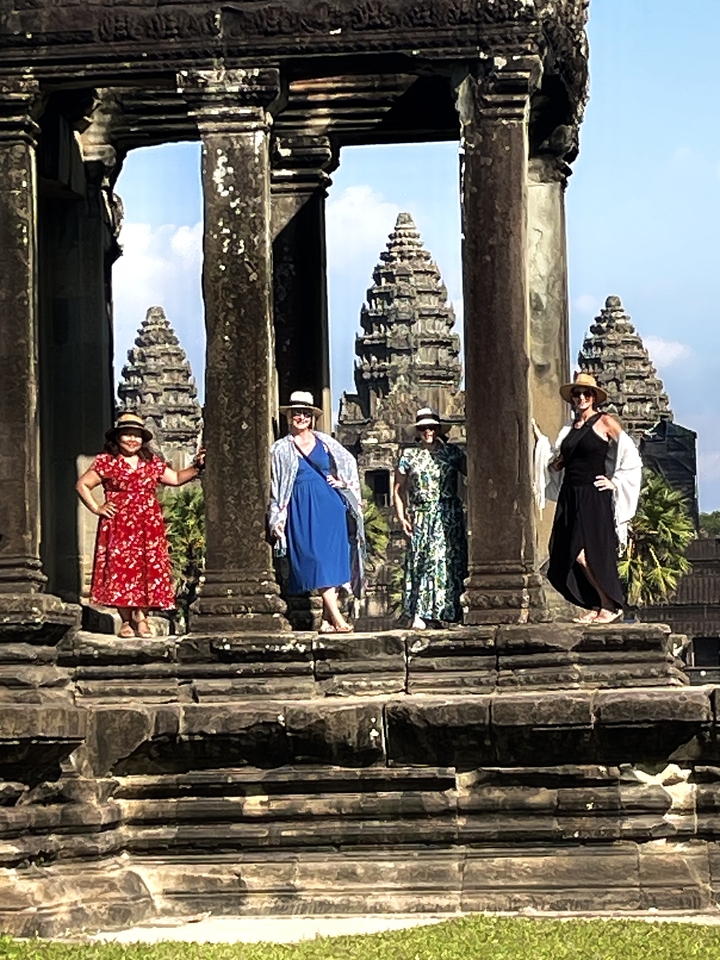 Groupe de femmes posant parmi des ruines antiques.