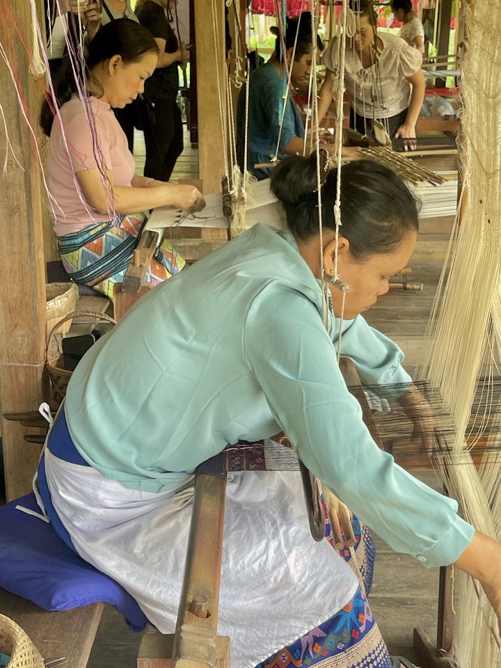 Des femmes tissant des tissus traditionnels dans un atelier.