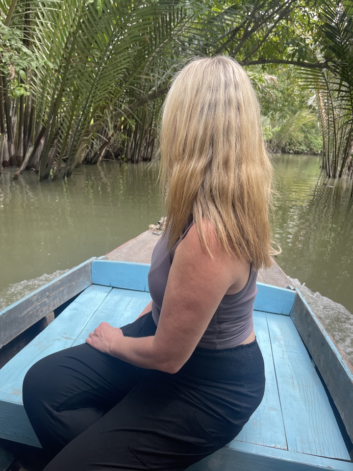 Femme assise à l'avant d'un bateau sur une rivière.