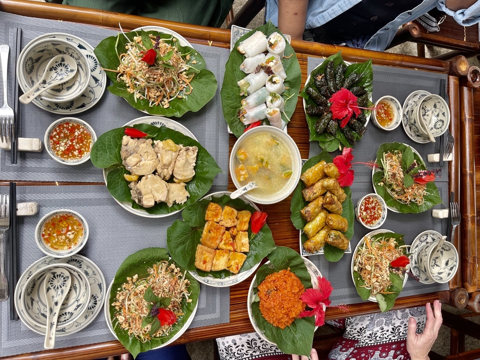 Assortiment de plats vietnamiens élégamment présentés sur des feuilles de bananier.