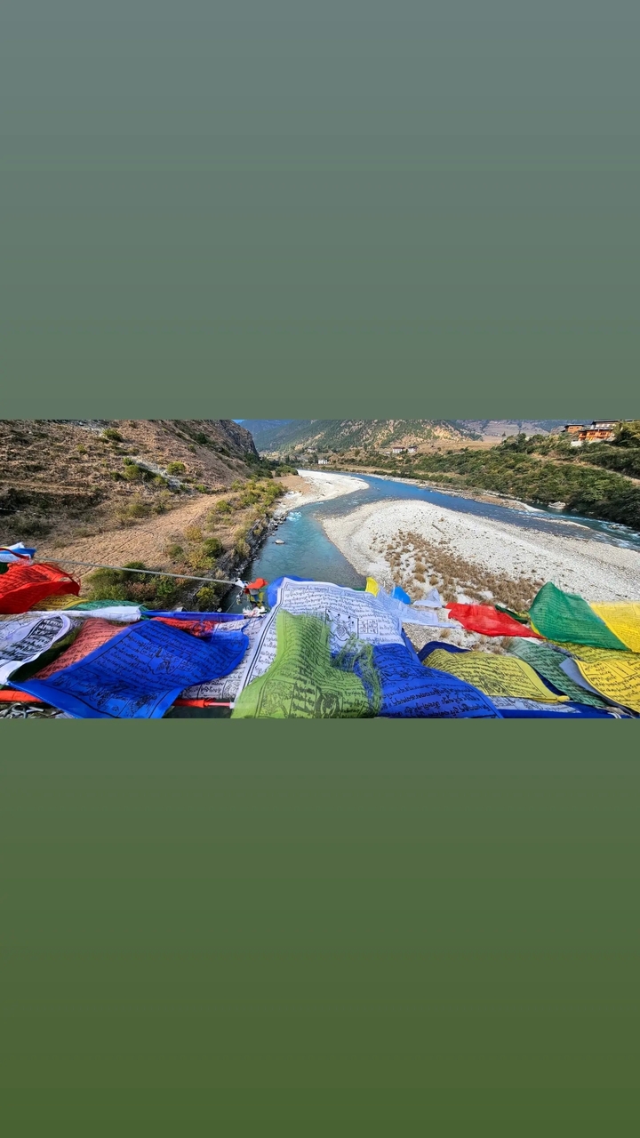 Drapeaux de prière décoratifs au-dessus d'une rivière et d'une vallée.