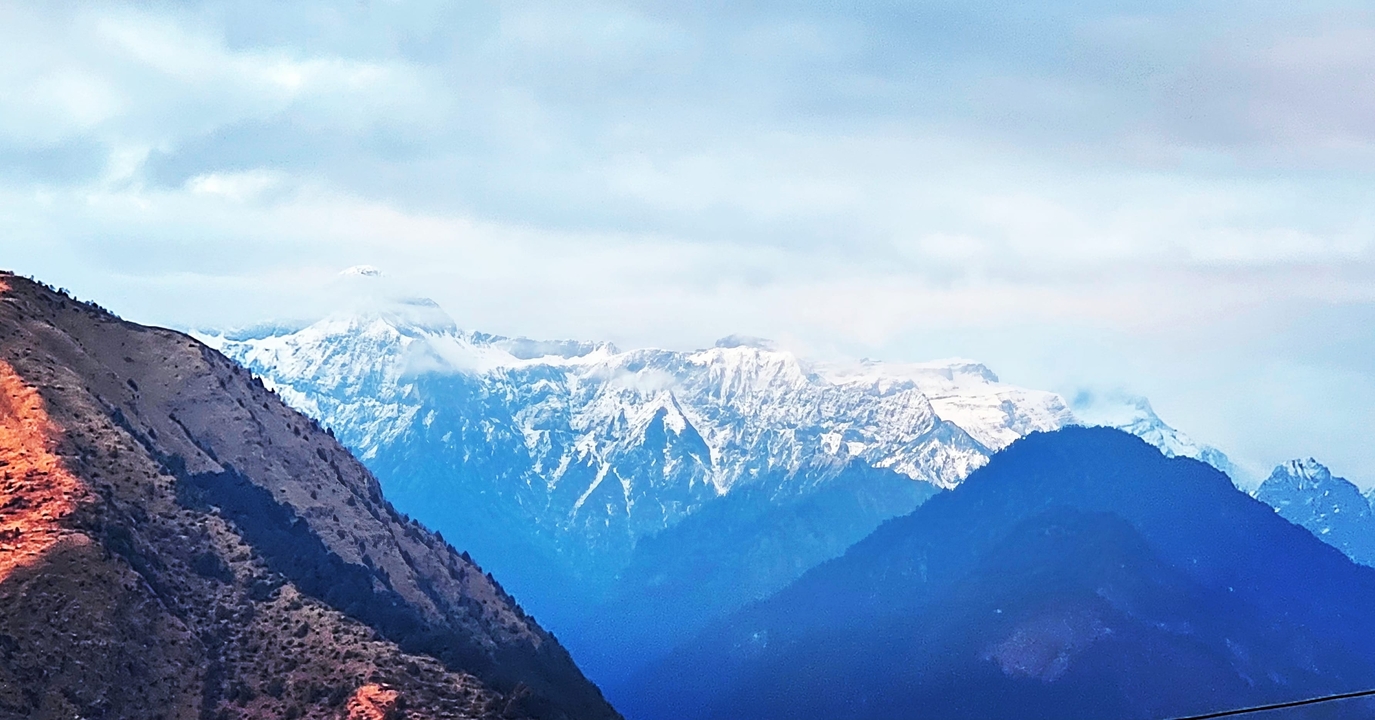 Chaîne de montagnes avec neige et nuages.