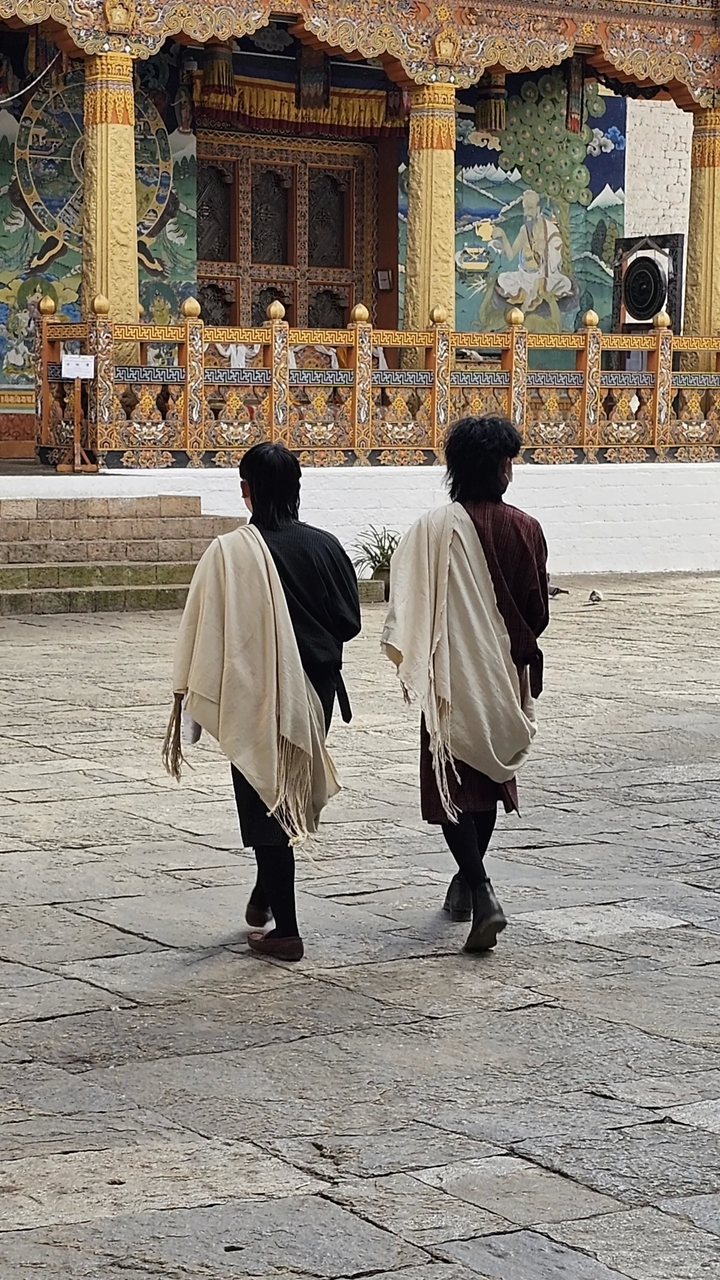 Deux personnes marchant en tenue traditionnelle.