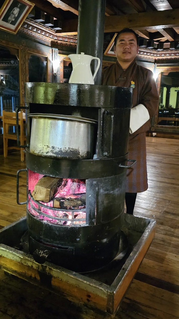 Poêle en métal avec une casserole et du bois de chauffage.