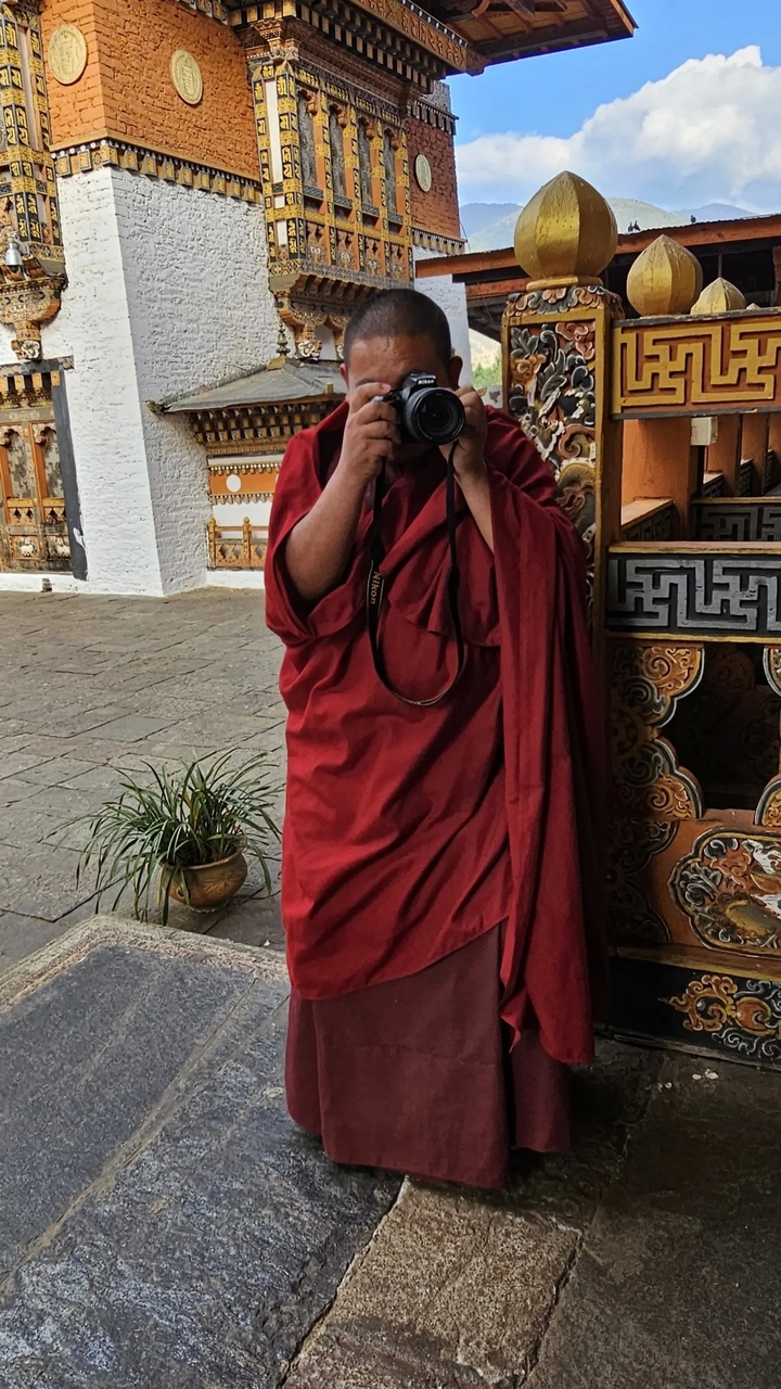 Personne déguisée en moine, prenant des photos.