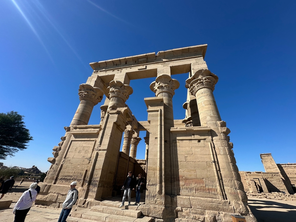 Ruines d'un temple égyptien antique sous un ciel bleu dégagé.