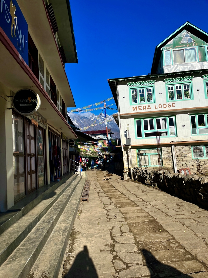 Rue étroite dans un village de montagne avec des gîtes colorés.