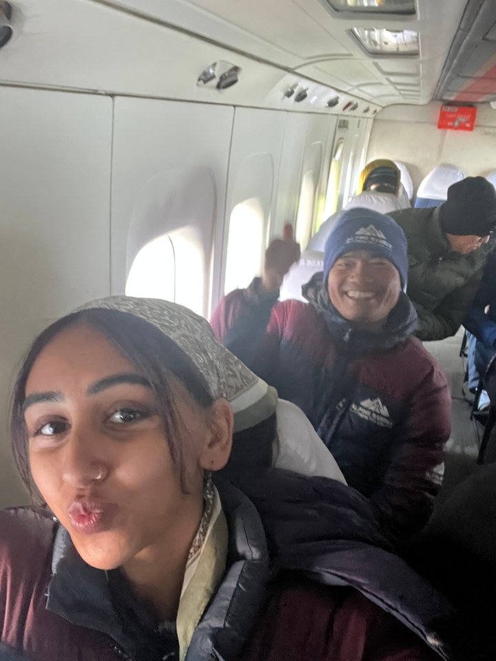 Des passagers souriants à l'intérieur de la cabine d'un avion.