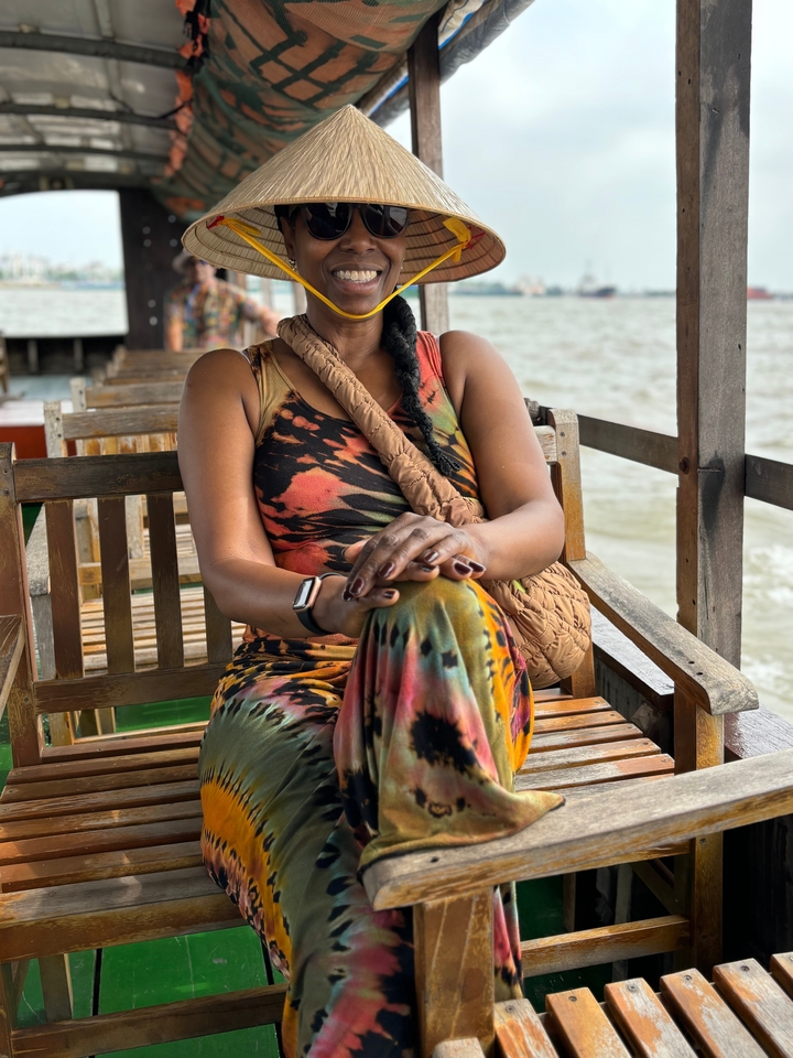 Personne assise sur un banc en bois au bord de l'eau.