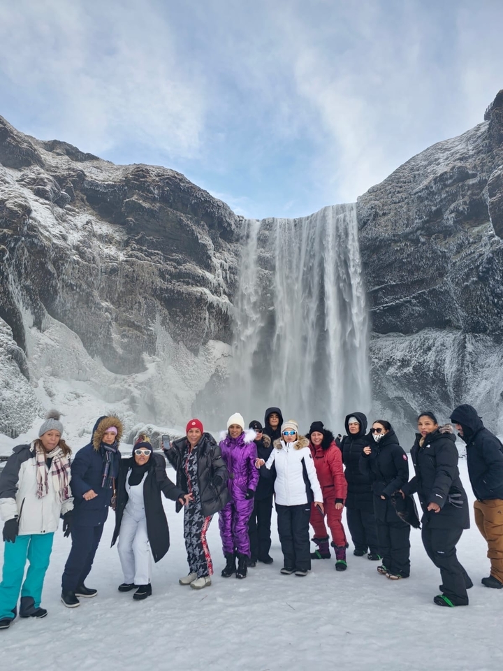 Groupe devant une grande cascade.