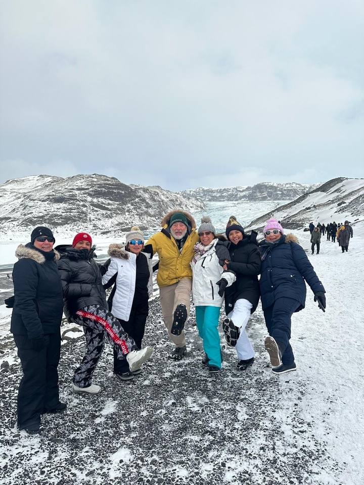 Groupe posant devant un paysage enneigé.