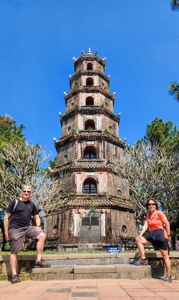 Homme posant devant la pagode Thien Mu.