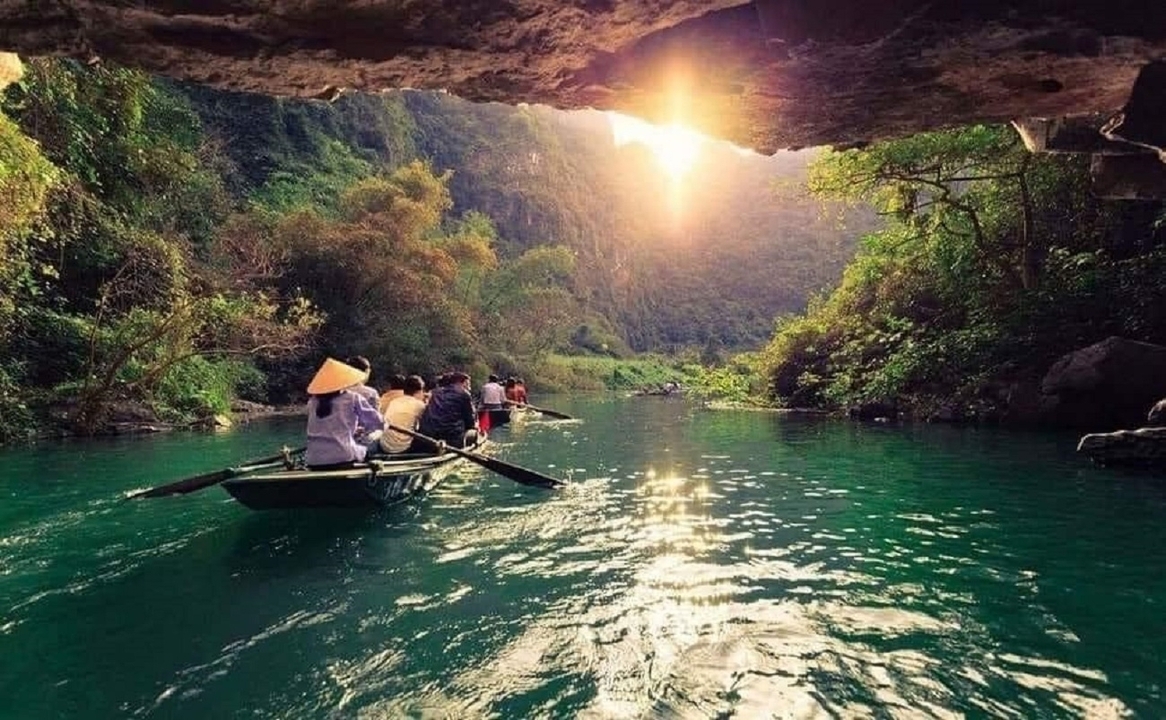 Des bateaux avec des personnes qui rament sur une rivière pittoresque.