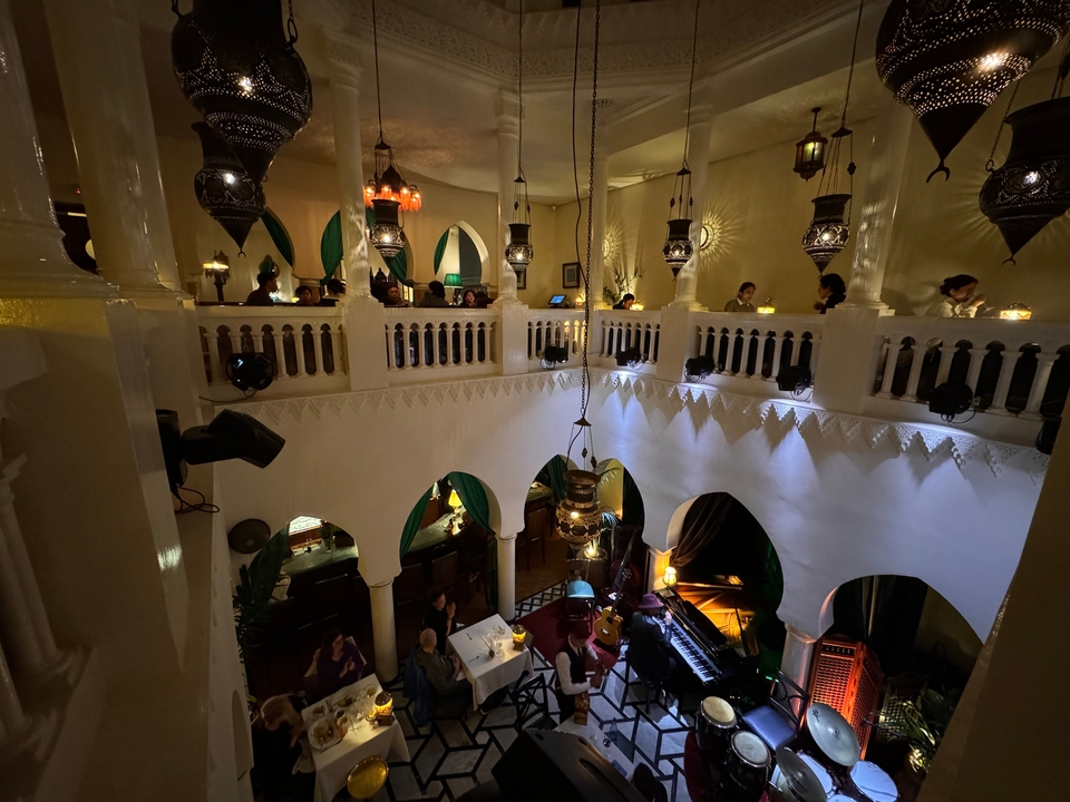 Un restaurant avec des personnes qui dînent sous un art marocain orné.