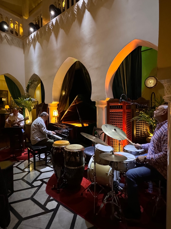 Des musiciens jouant des instruments dans une pièce chaleureuse faiblement éclairée.