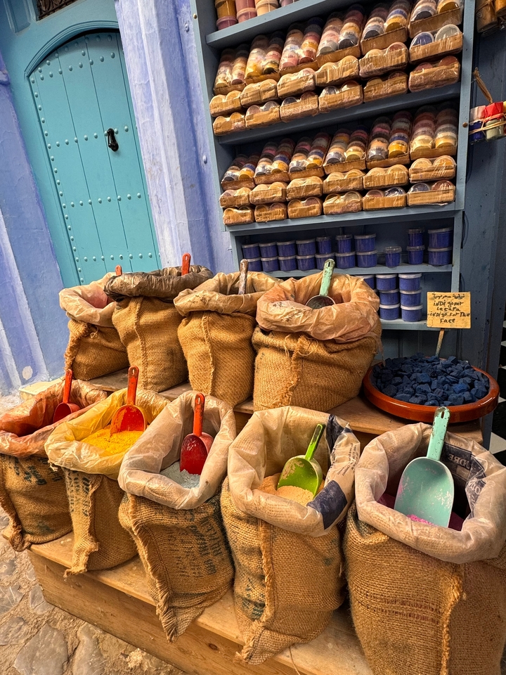 Étals de marché avec des sacs d'épices et d'herbes colorées.