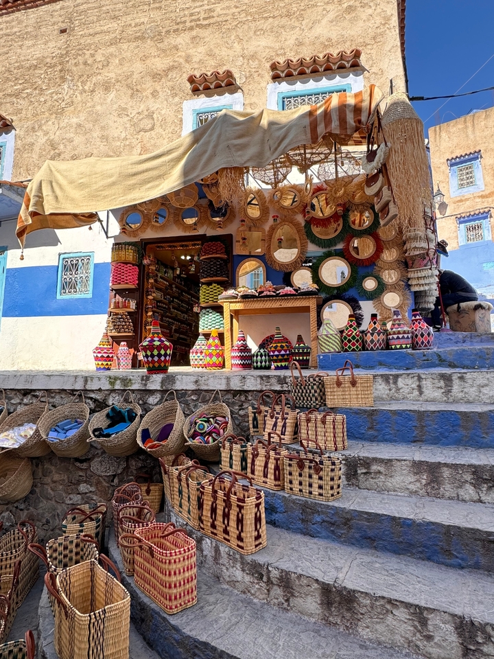 Un étalage coloré de paniers et d'articles artisanaux devant une boutique.
