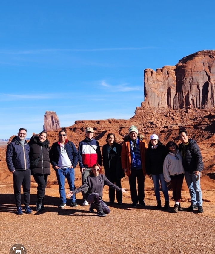 Groupe de personnes posant devant des formations rocheuses rouges.