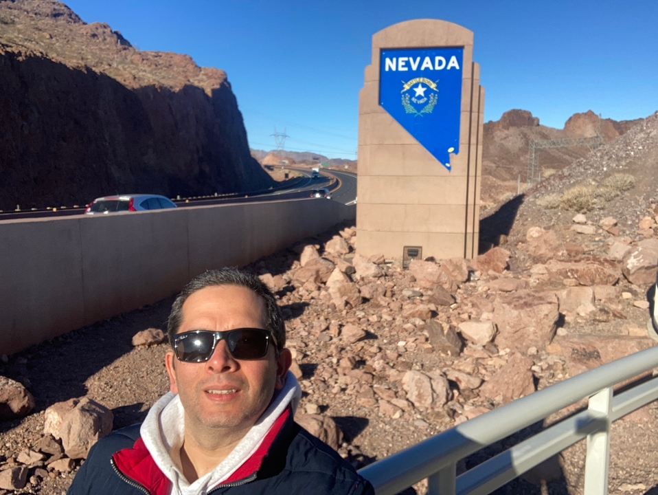 Personne qui pose près d'un panneau d'autoroute dans une zone désertique rocheuse.