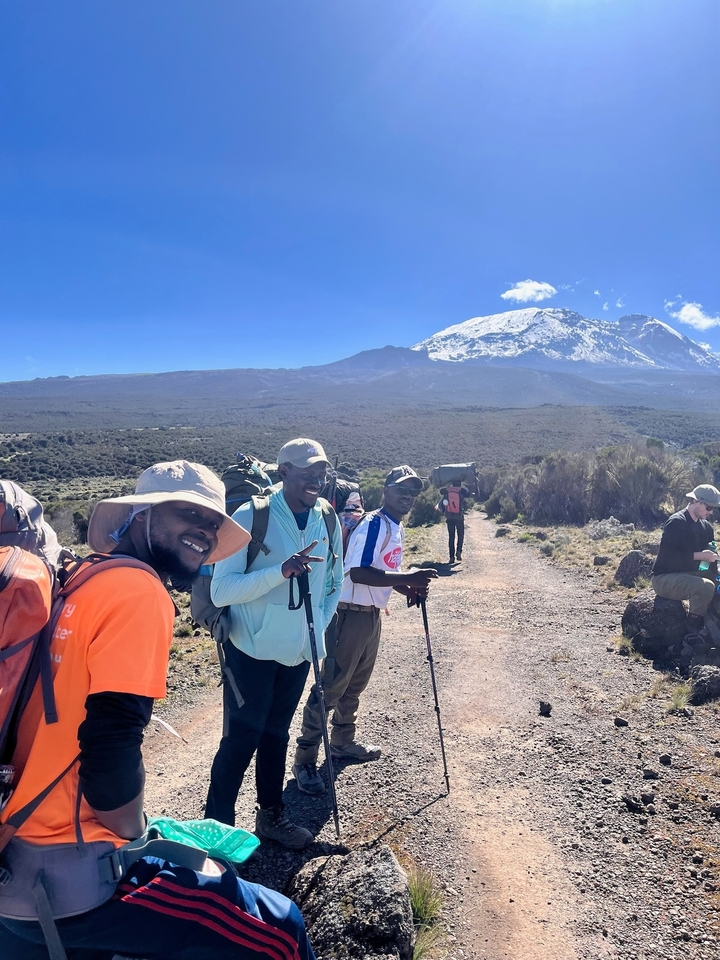 Groupe de randonneurs sur un sentier avec des montagnes enneigées