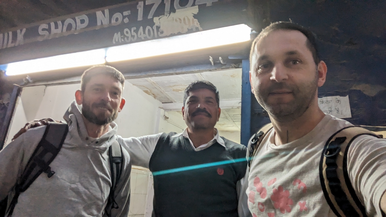Trois hommes posant devant un magasin.