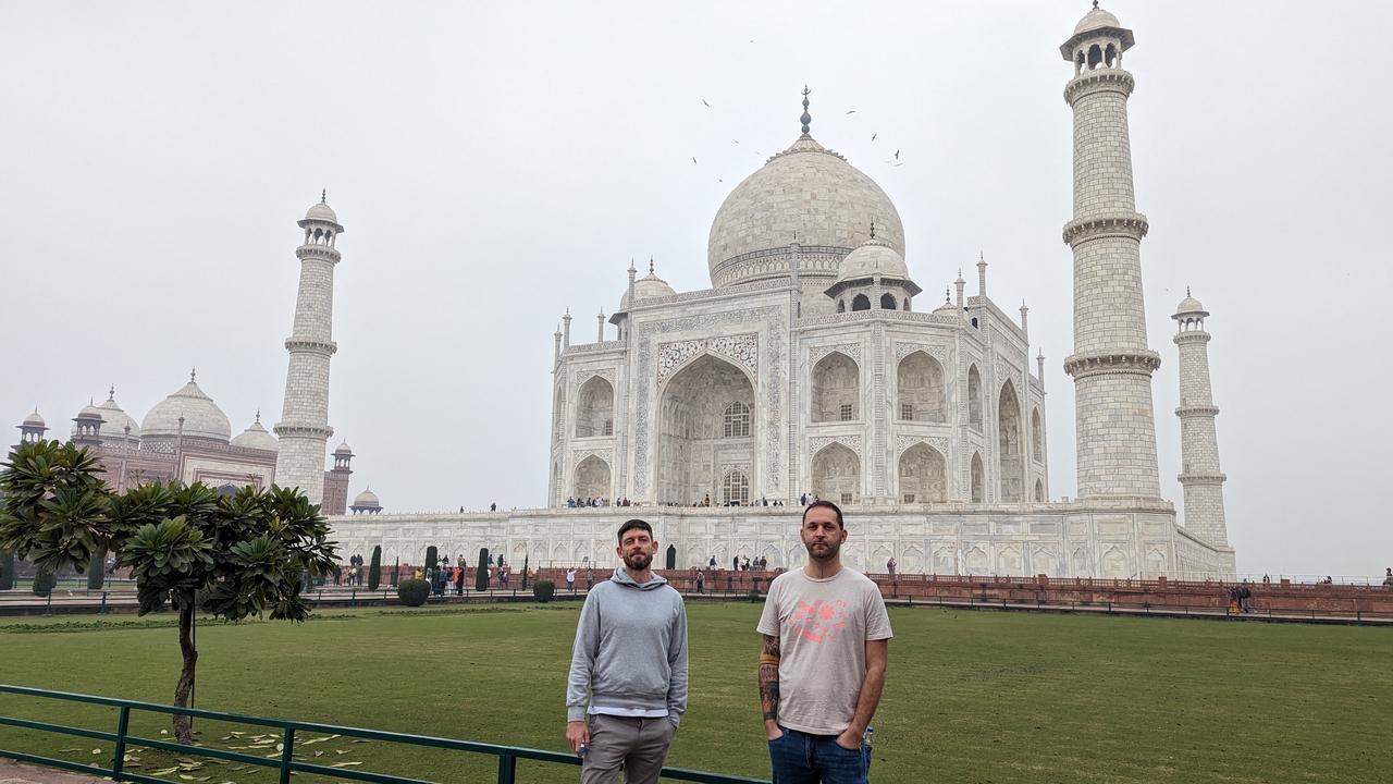 Deux hommes debout devant le Taj Mahal.