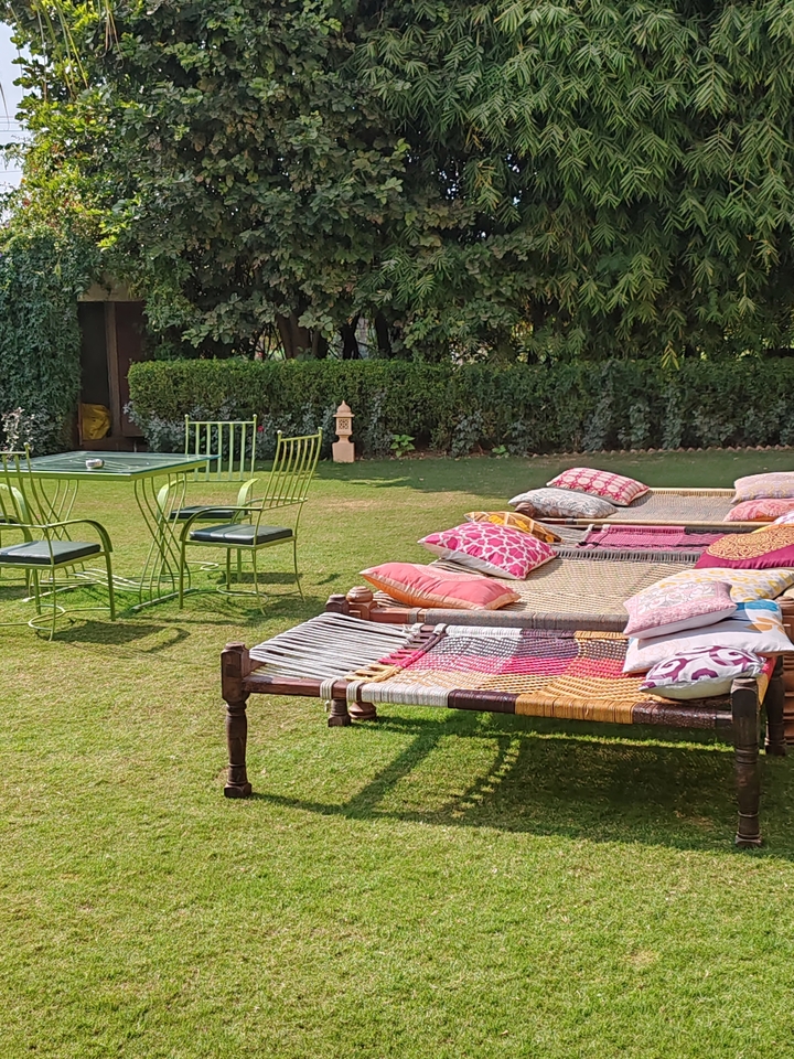 Espace de détente extérieur avec hamacs et coussins colorés.