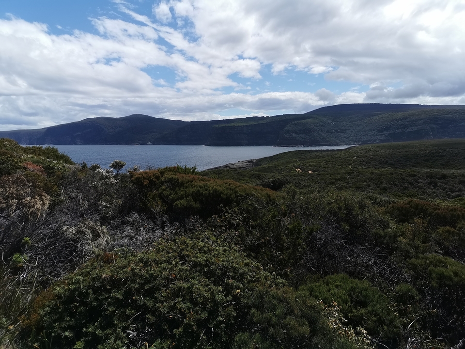Colline surplombant un littoral avec océan.